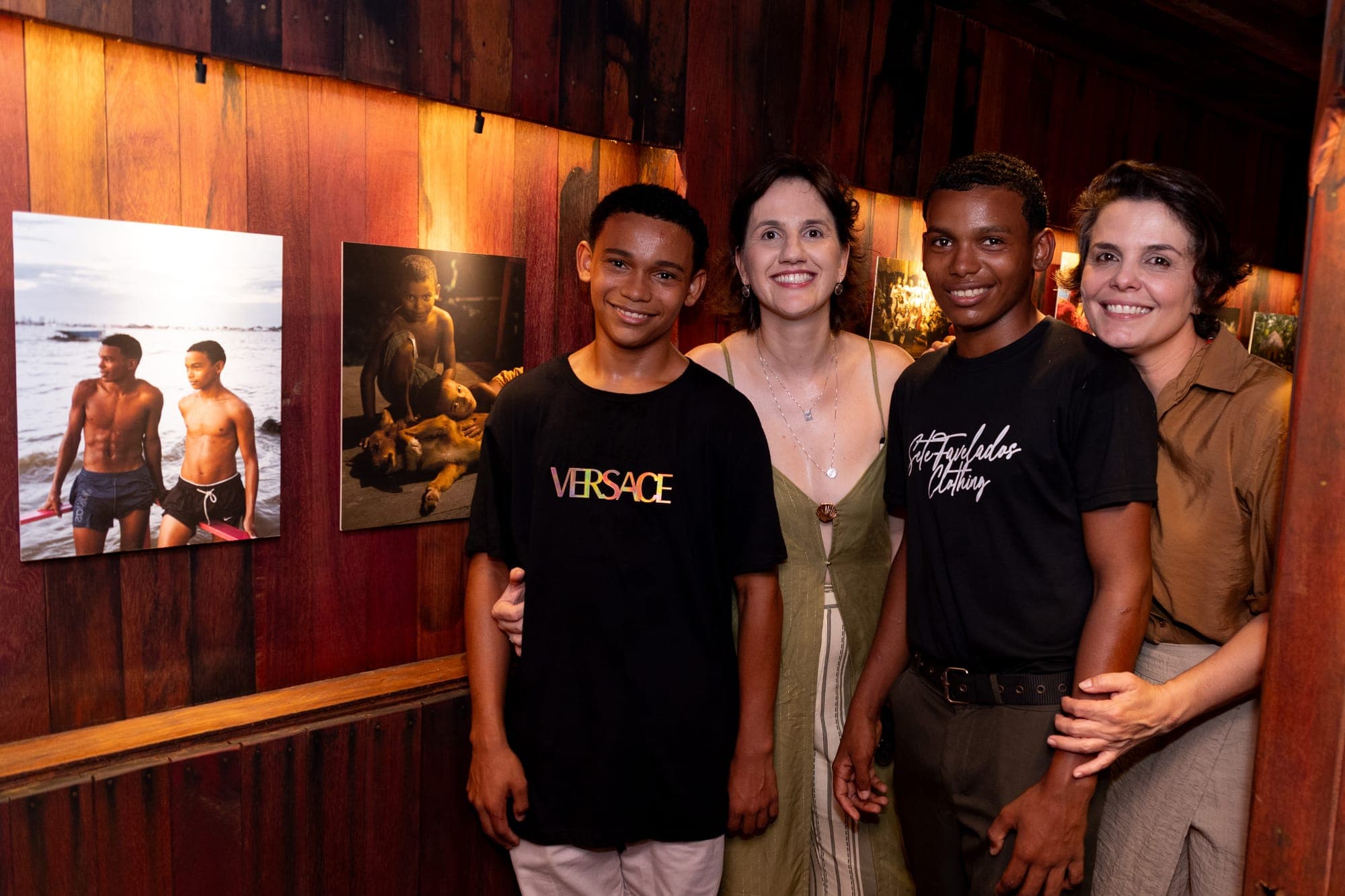 Visitantes posam diante das fotografias expostas