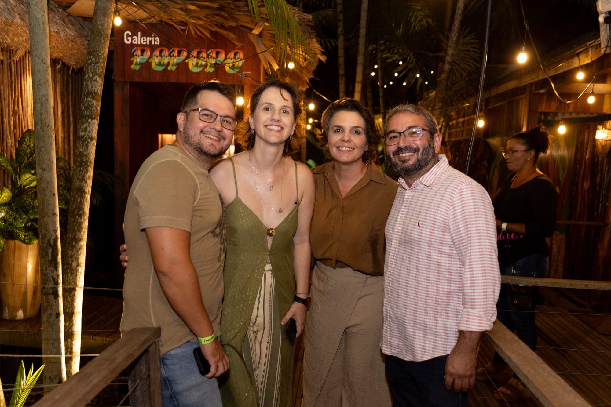 Convidados posam diante da fachada da galeria