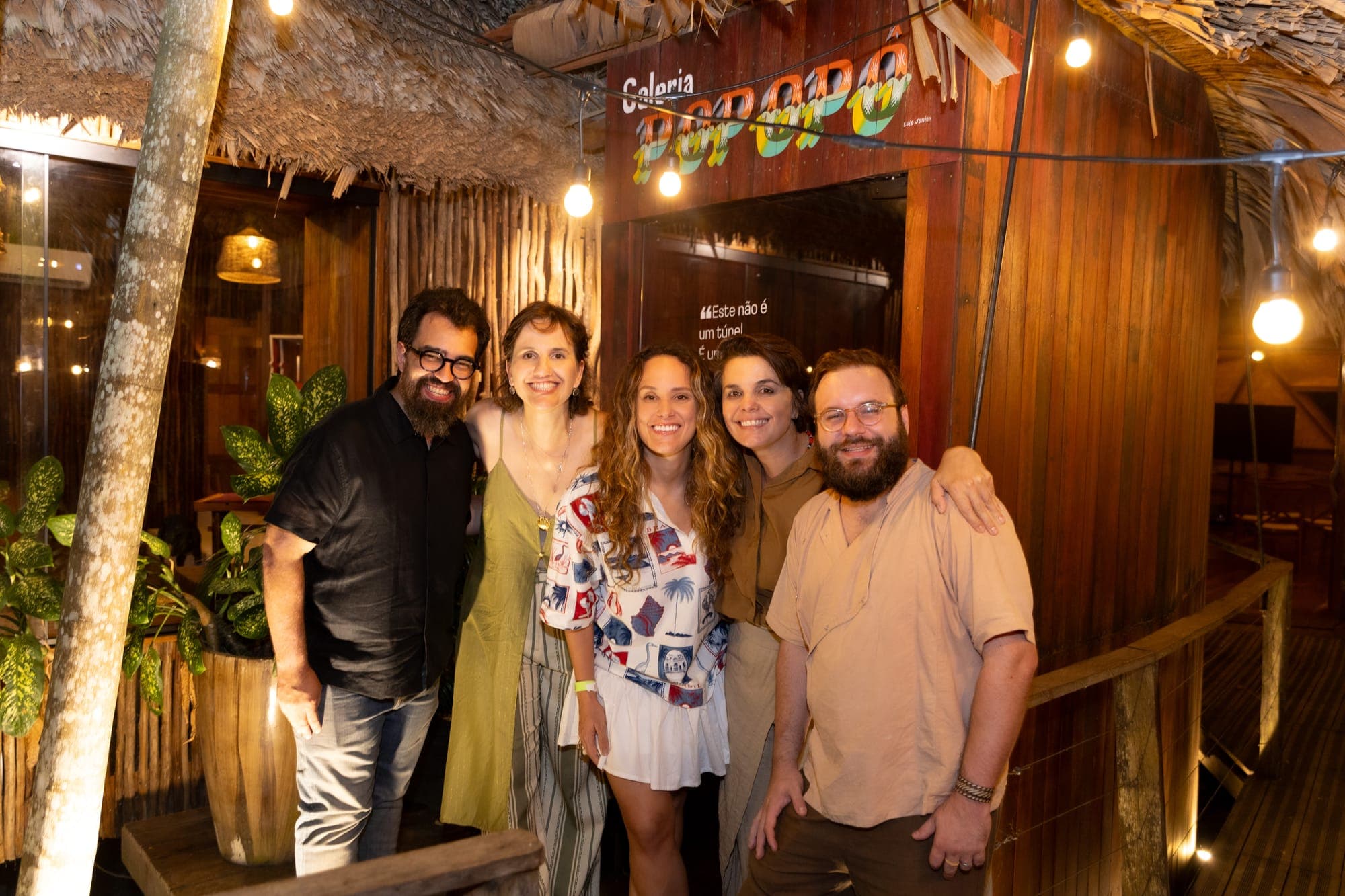 Convidados posam diante da fachada da galeria