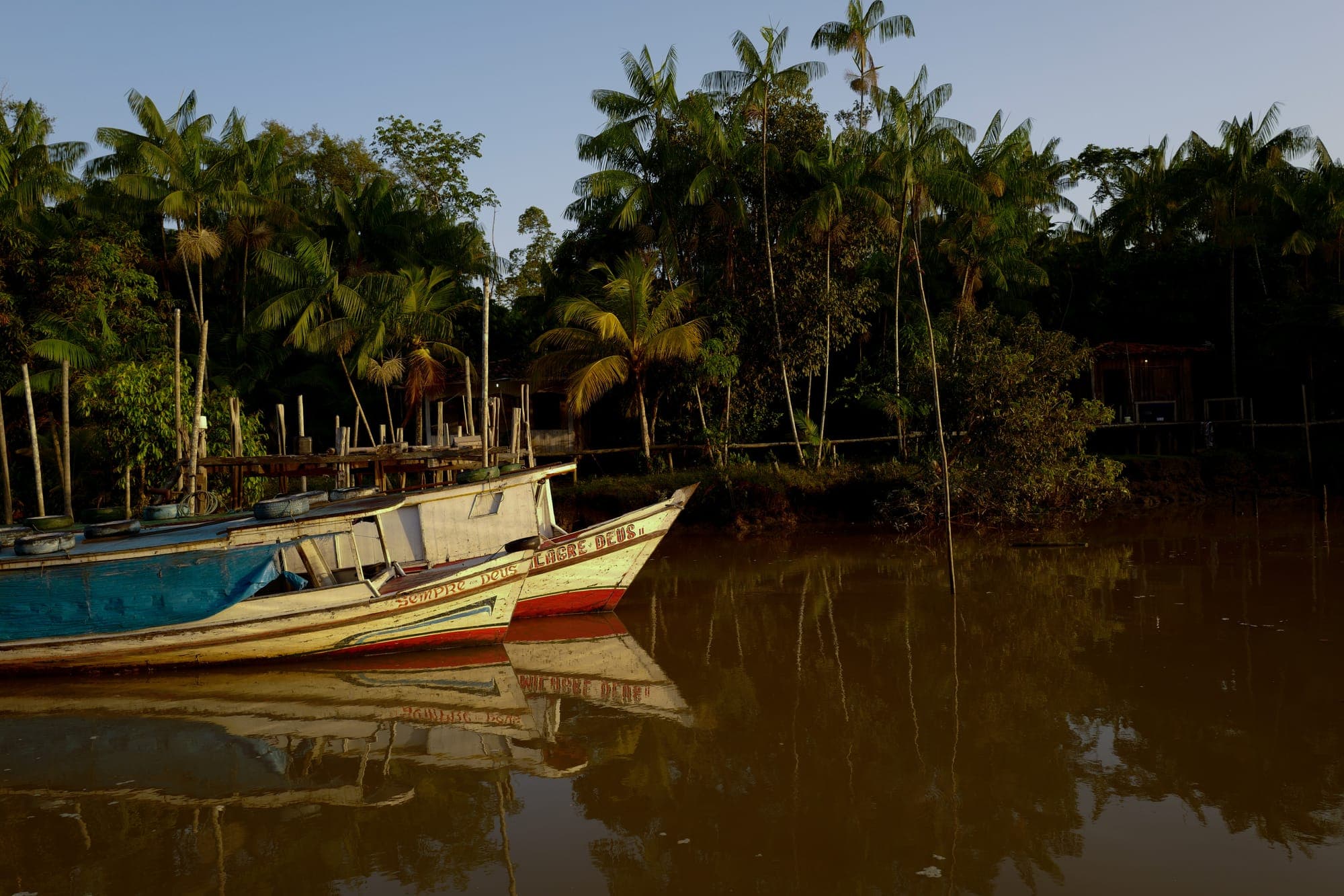 Barcos atracados na margem do rio sob o céu azul