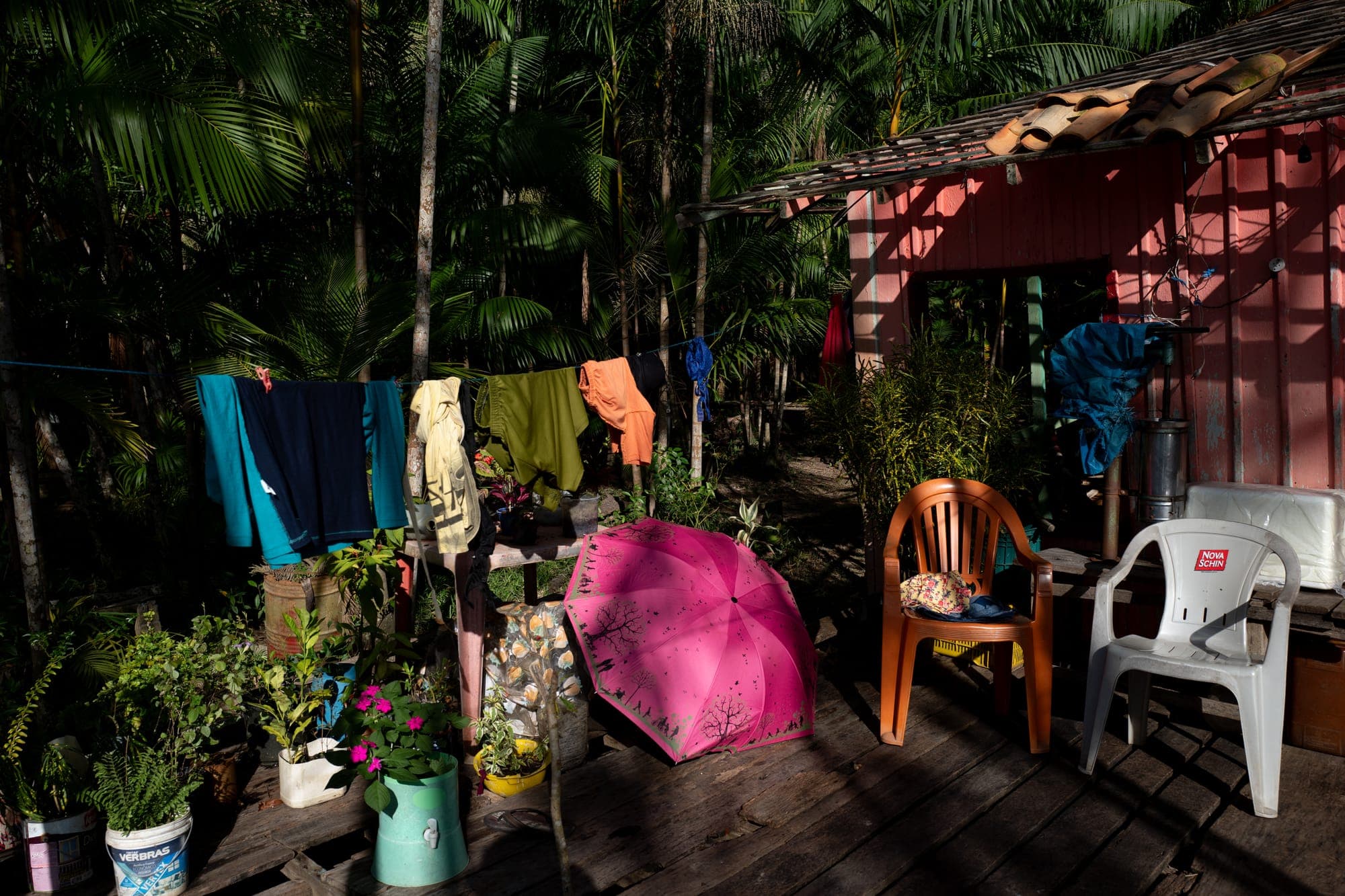 Quintal de casa ribeirinha com roupas no varal e cadeiras