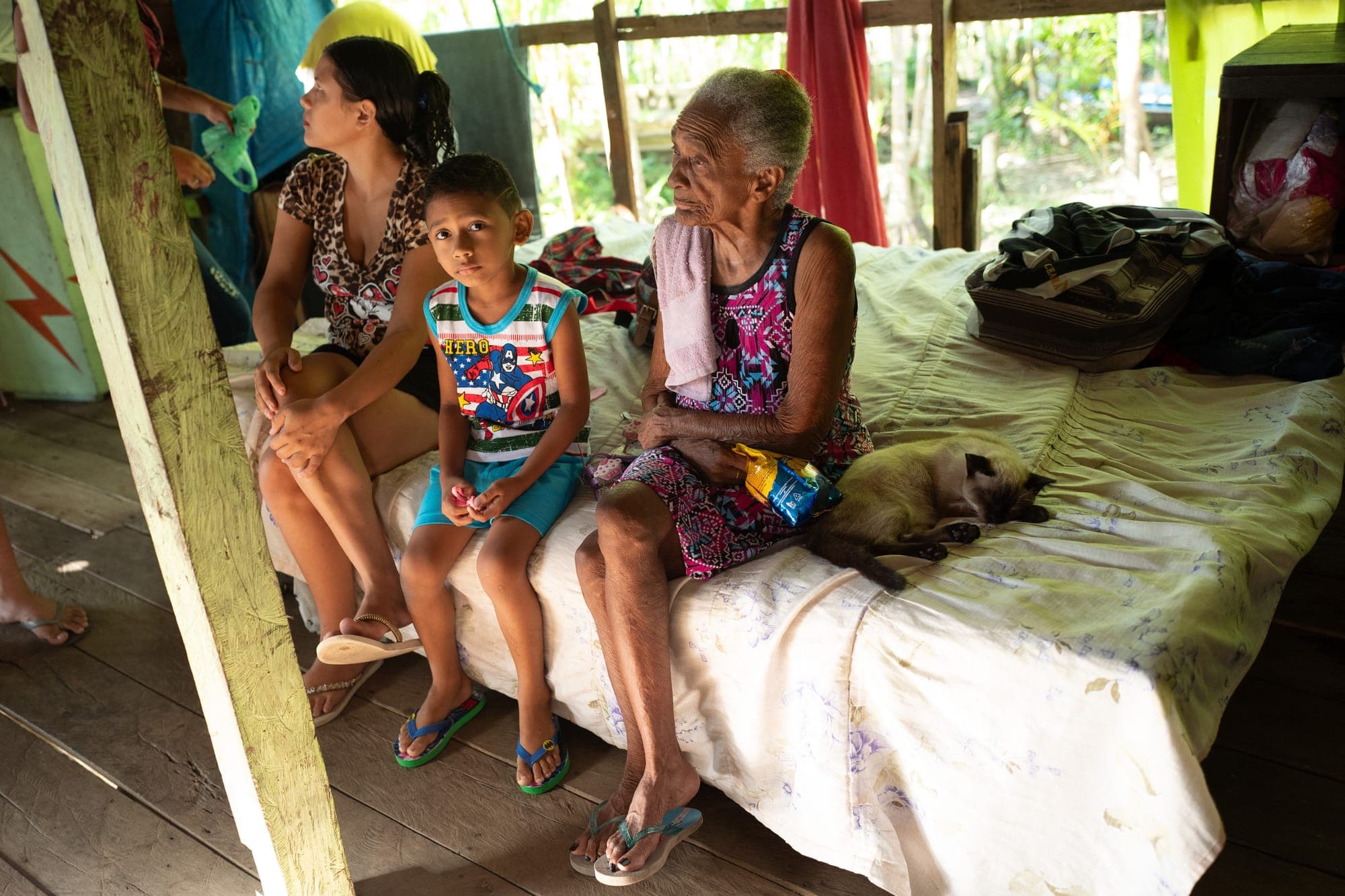 Família reunida sobre a cama dentro de casa