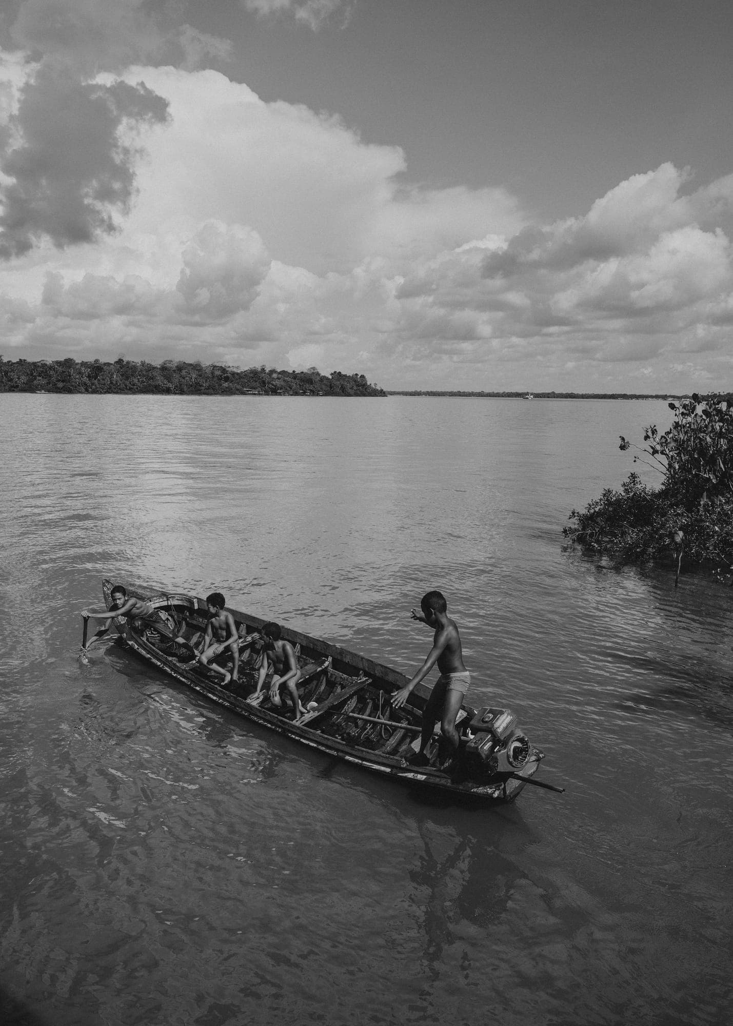 Canoa com crianças no rio, em preto e branco