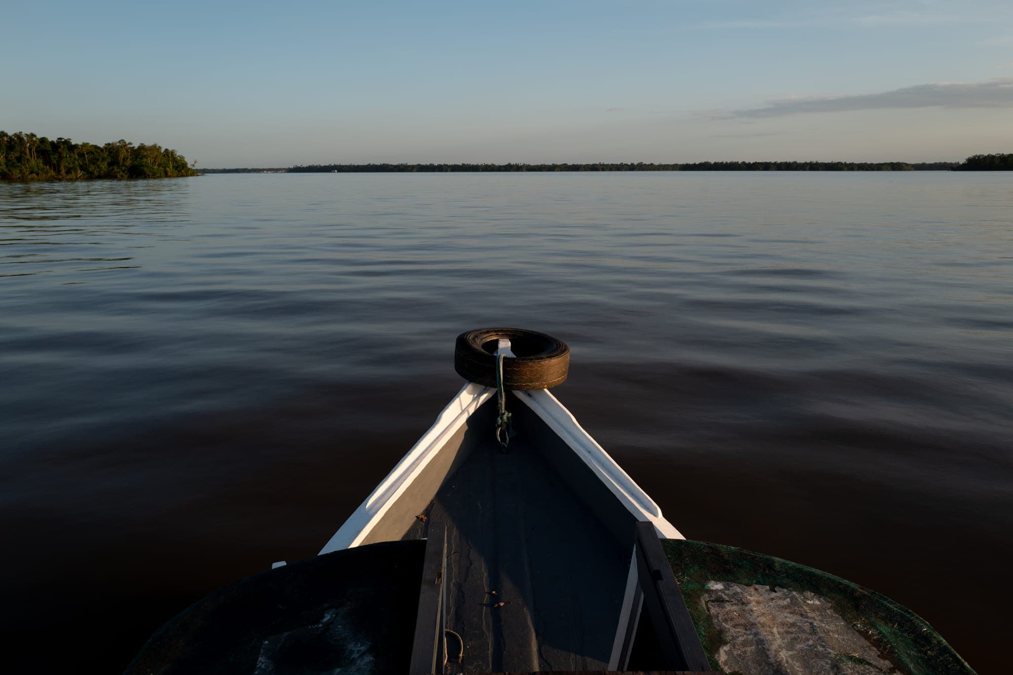Proa de canoa no rio ao entardecer