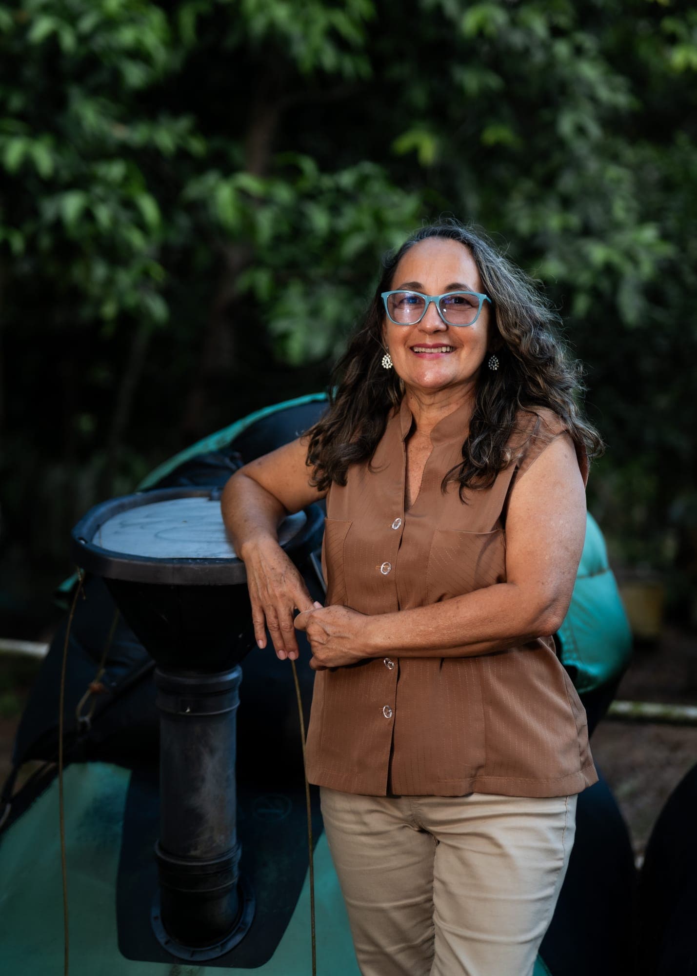 Mulher sorri de pé ao lado de um barco