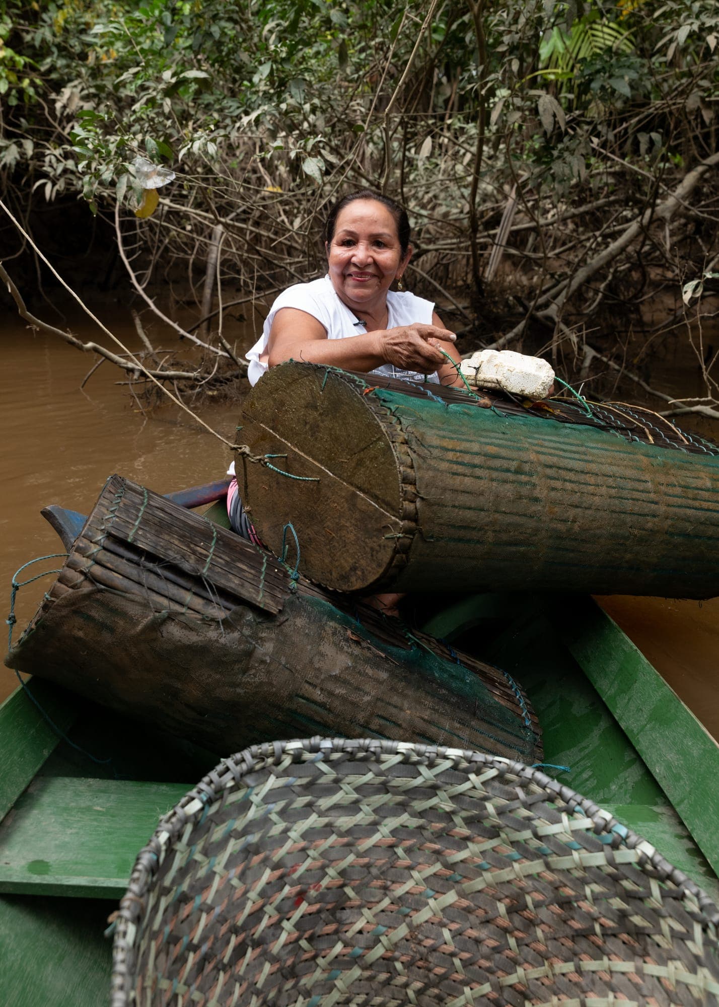 Mulher sorri em um barco carregado de matapis