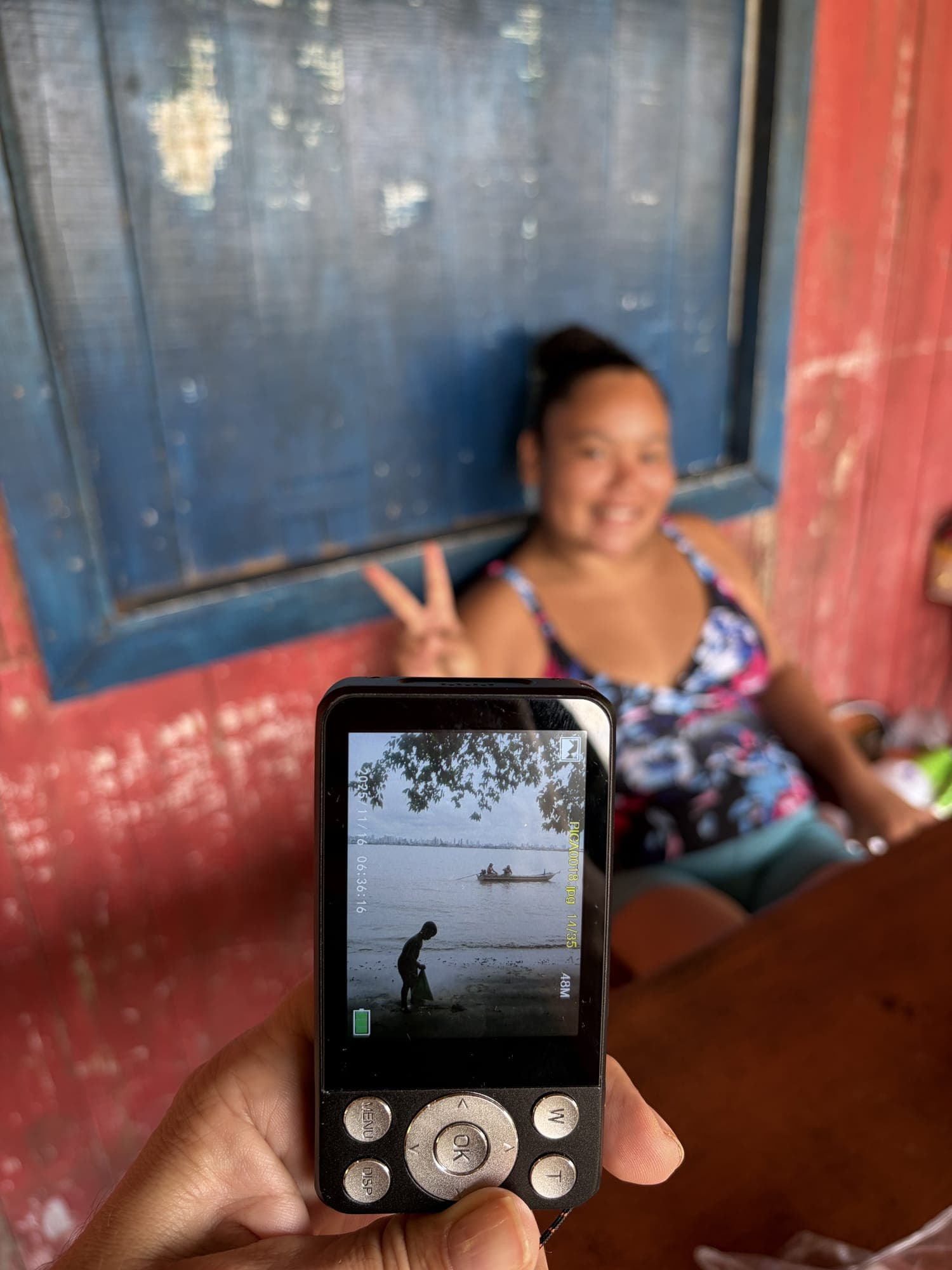 Tela de uma câmera mostra uma foto, com a moradora fotografada ao fundo