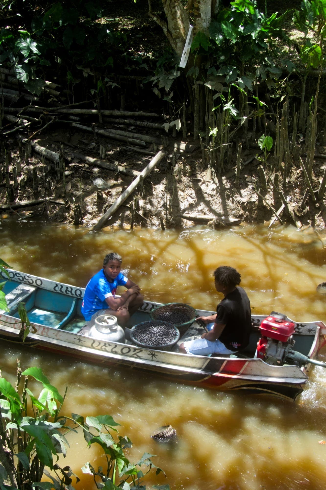 Canoa carregada navega pelo igarapé