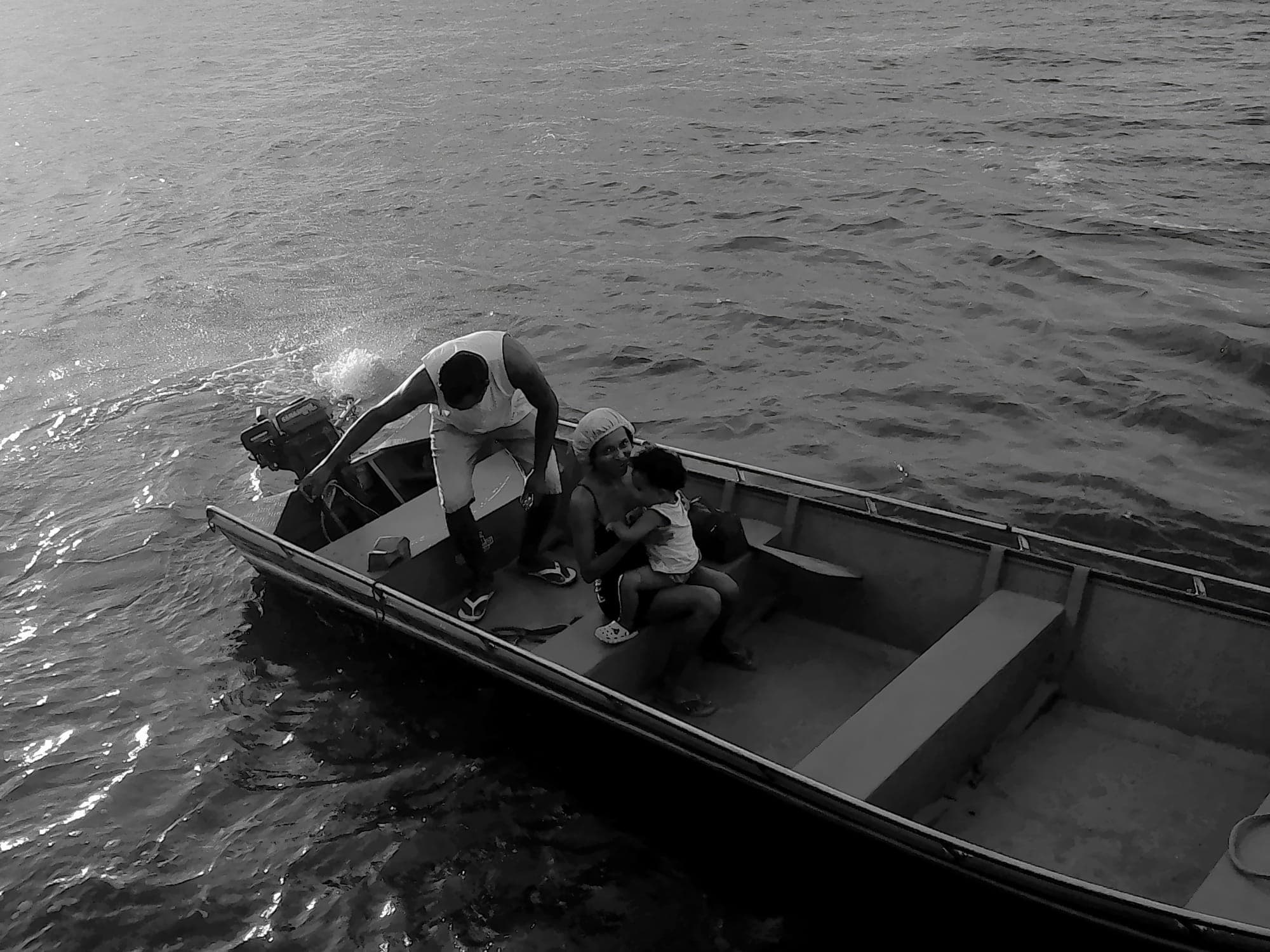 Crianças em uma canoa no rio, em preto e branco