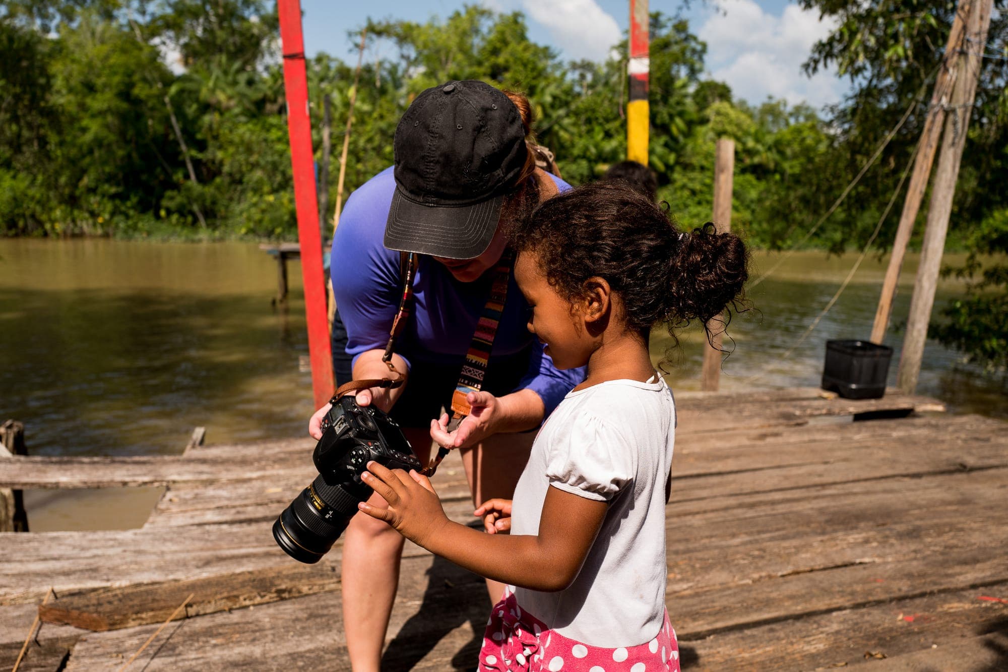 Fotógrafo mostra a câmera a uma menina no trapiche