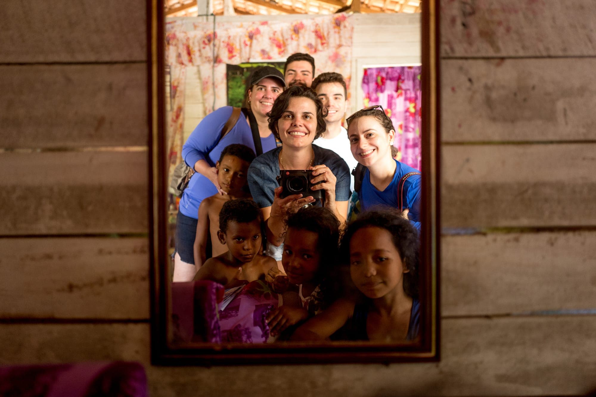 Participantes e moradoras refletidas em um espelho na parede