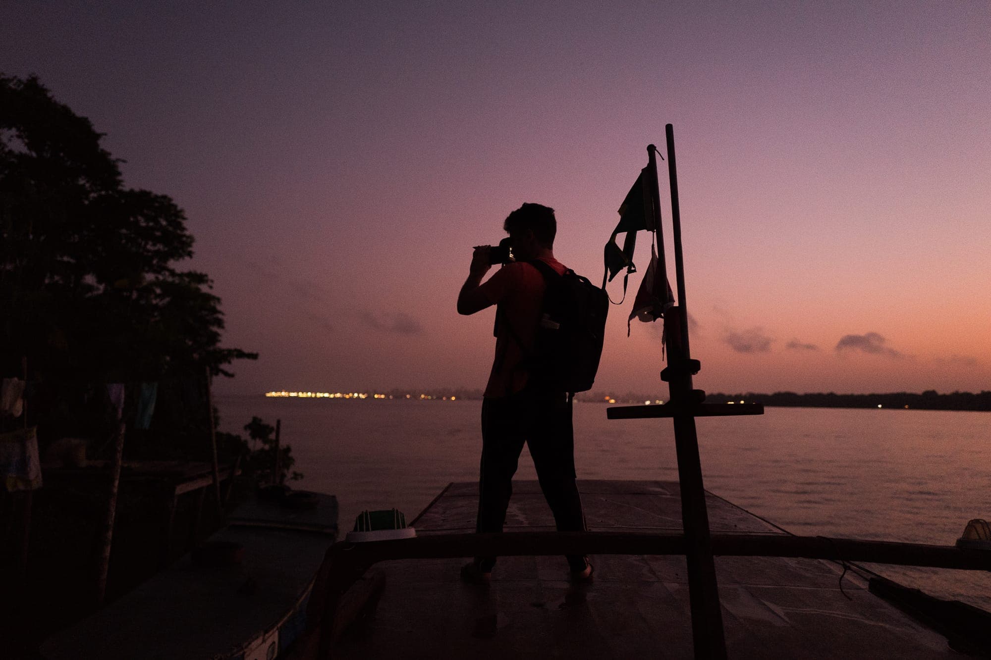 Silhueta de fotógrafo no barco ao entardecer