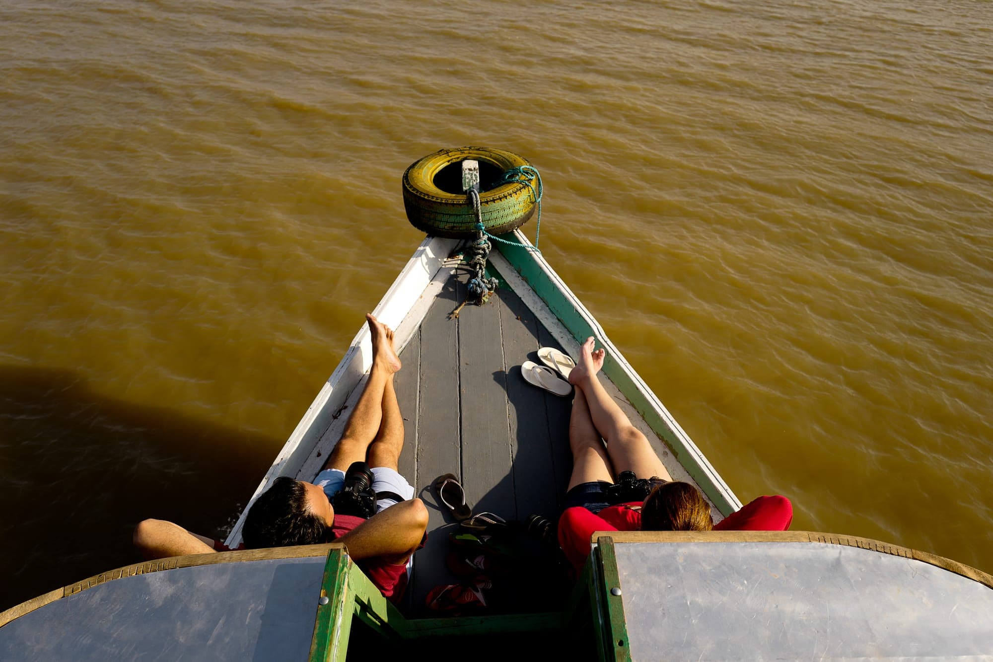 Participantes deitados na proa do barco