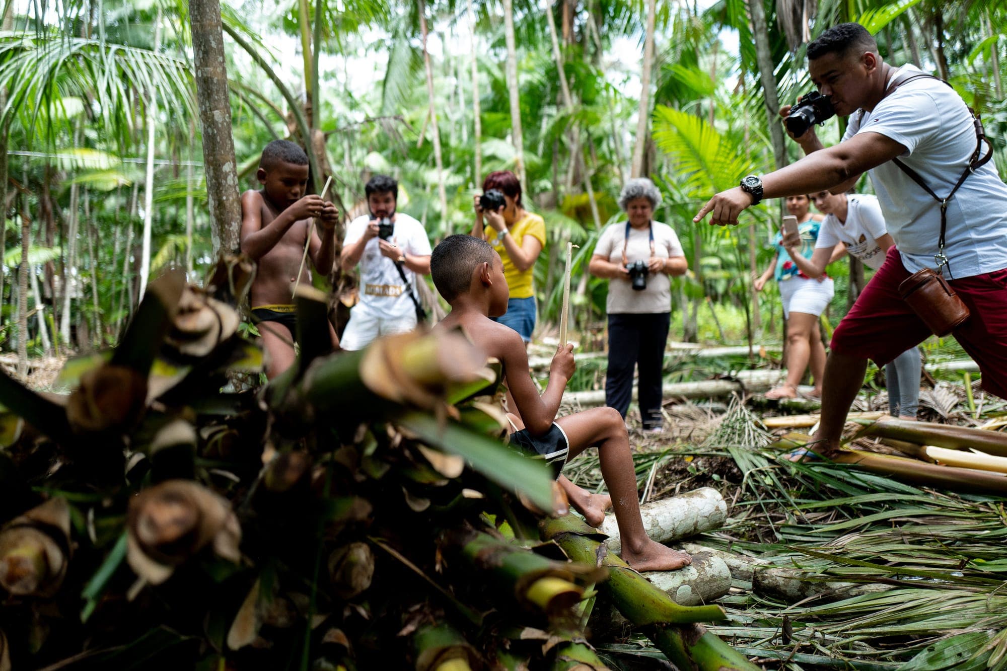Grupo fotografa um morador trabalhando na mata