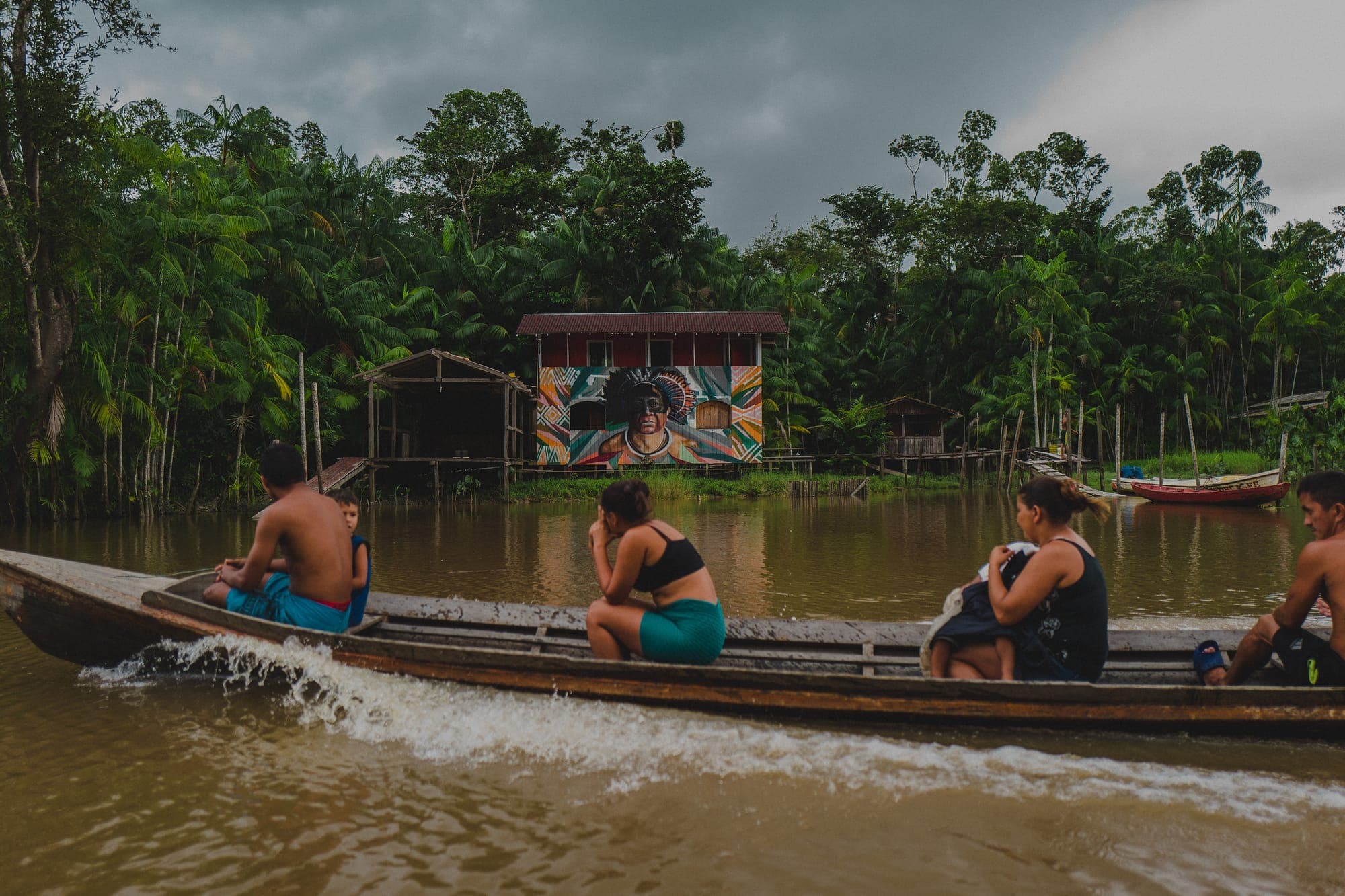 Participantes navegam em uma rabeta pelo rio