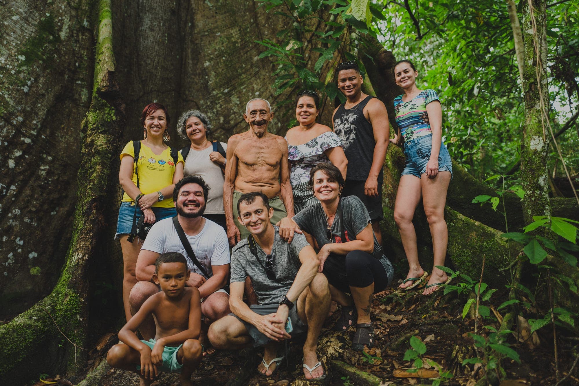 Grupo posa junto ao tronco de uma grande árvore